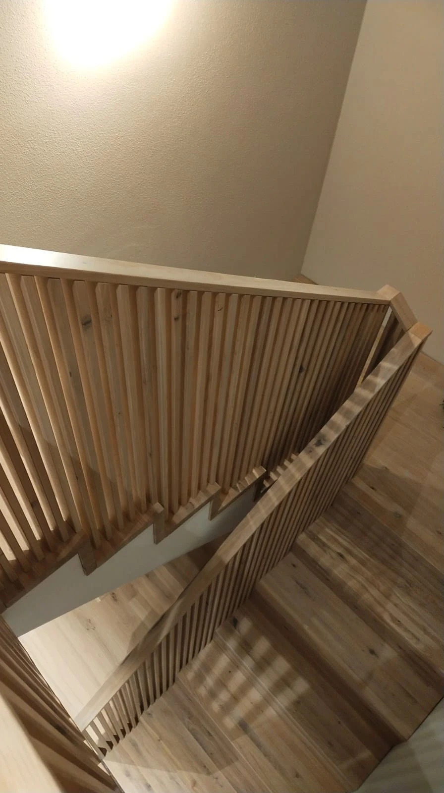 Betontreppe in Faltwerkoptik mit Wildeiche-Stufen und filigranem Holzstabgeländer 1