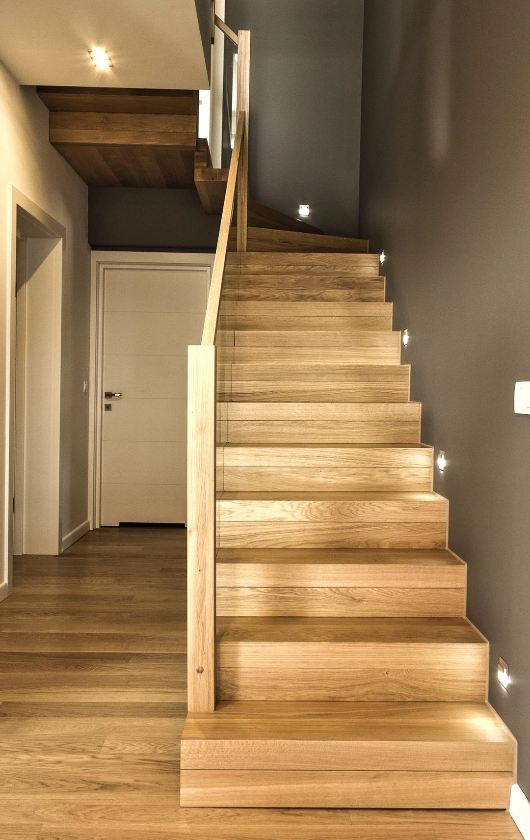 Moderne Faltwerktreppe mit lackierten Naturholzstufen und Glaswand  1