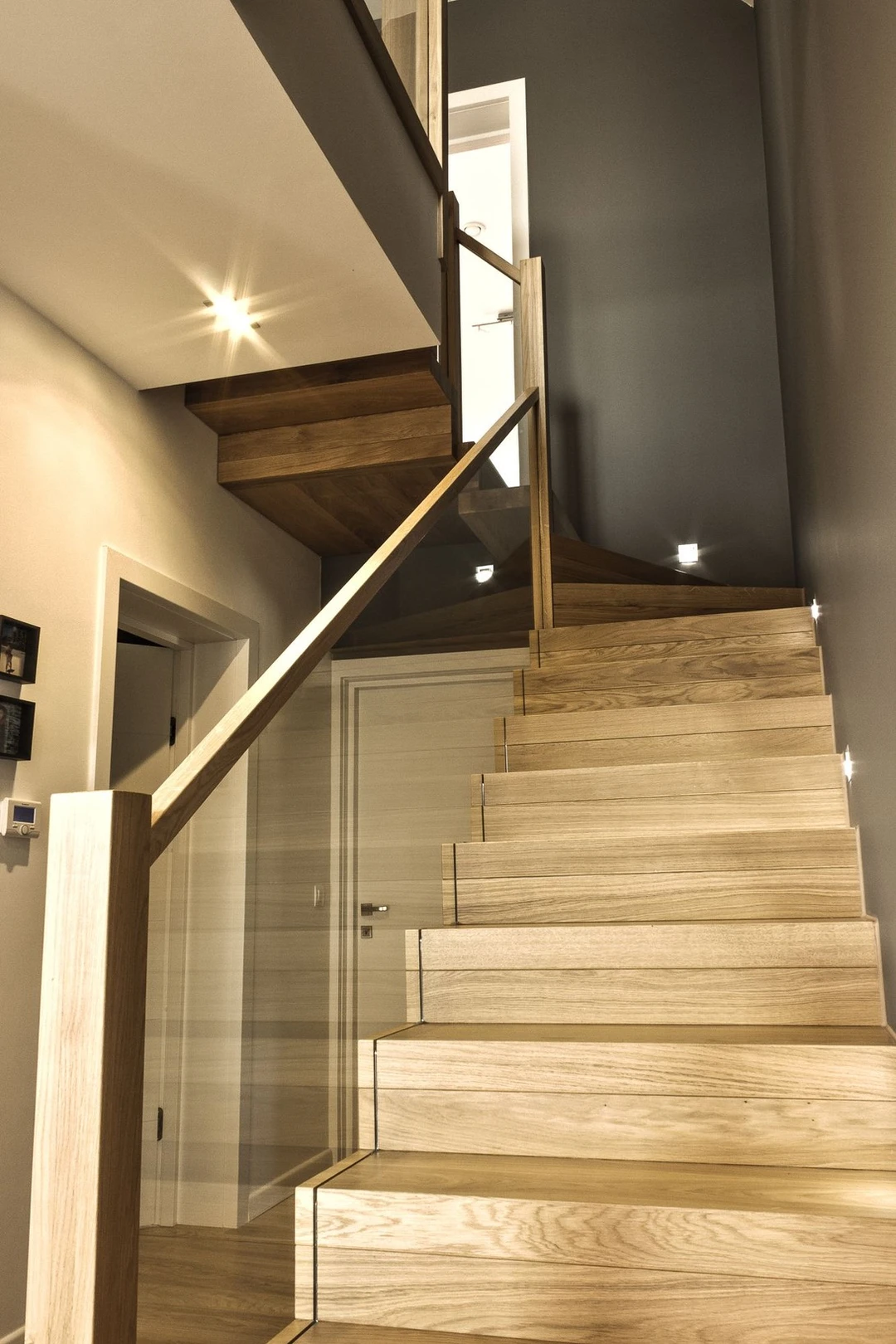 Moderne Faltwerktreppe mit lackierten Naturholzstufen und Glaswand  2