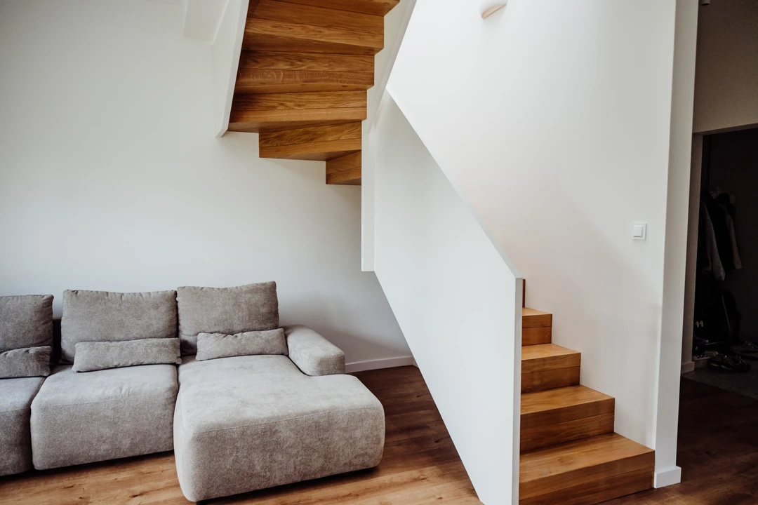 Moderne Faltwerktreppe mit Vollwandgeländer und weiß lackiertem Handlauf, Stufen in Naturholzfarbe lackiert  1