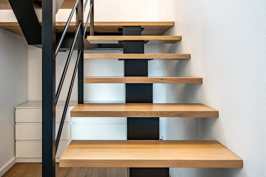 Moderne Mittelholmtreppe mit Relinggeländer, Holzstufen und schwarzer Konstruktion  1