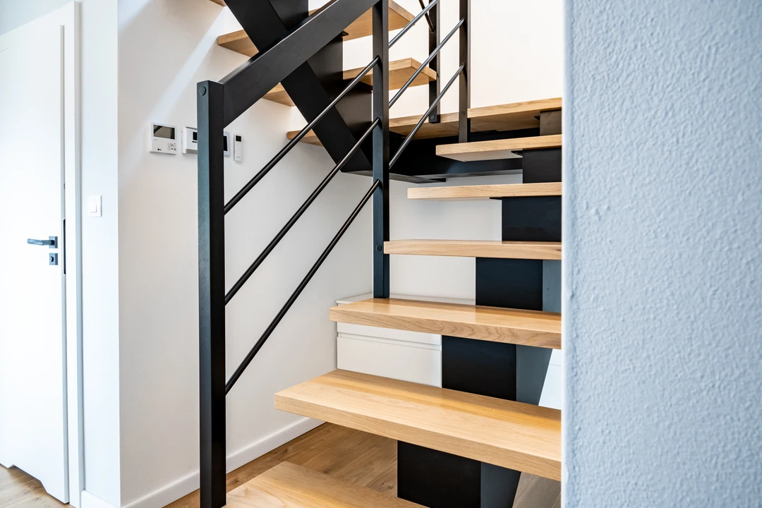 Moderne Mittelholmtreppe mit Relinggeländer, Holzstufen und schwarzer Konstruktion  2