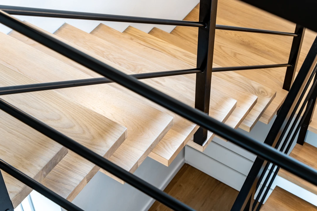 Moderne Mittelholmtreppe mit Relinggeländer, Holzstufen und schwarzer Konstruktion  3