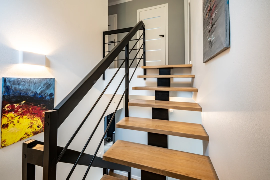 Moderne Mittelholmtreppe mit Relinggeländer, Holzstufen und schwarzer Konstruktion  4