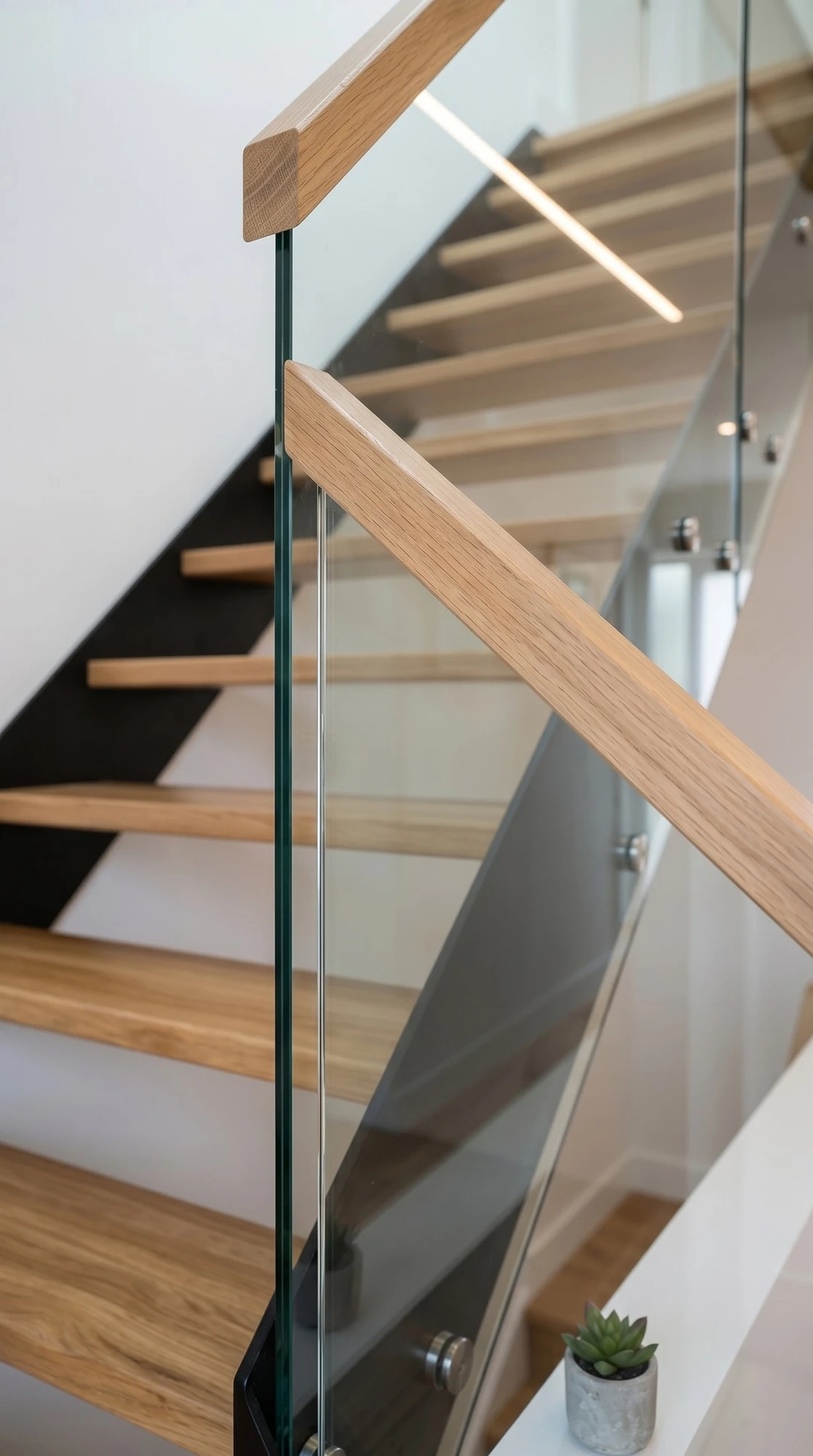 Moderne Stahlwangentreppe mit Eichenstufen und Glasgeländer 1