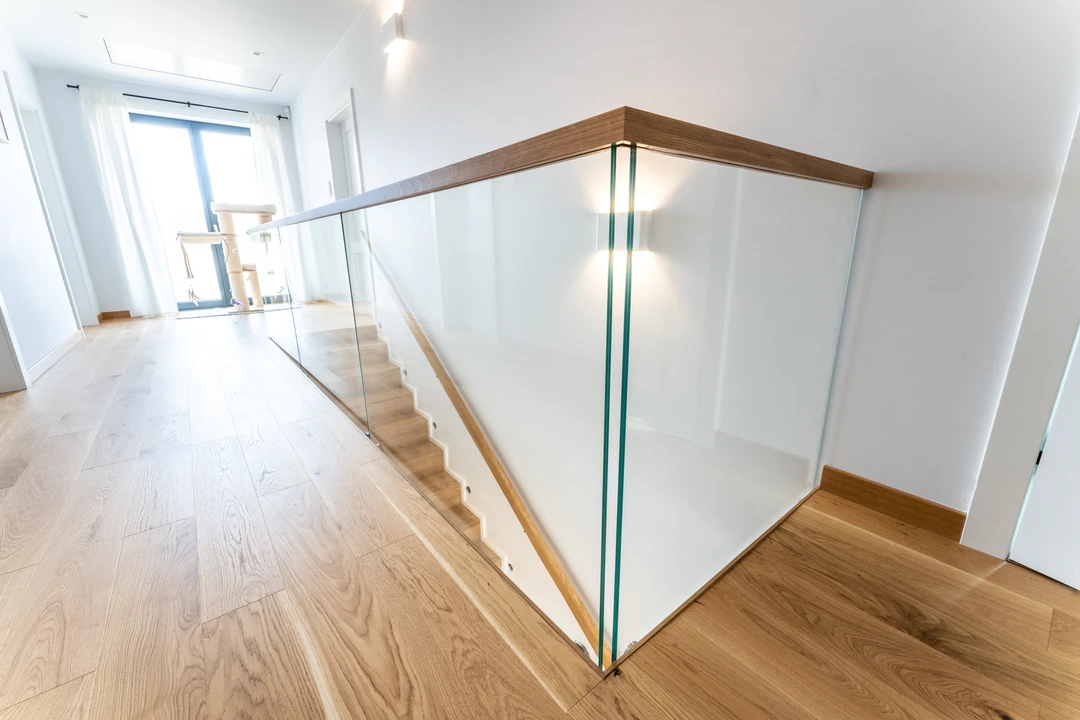 Moderne Stufen auf Beton (Treppe in Faltwerkoptik) mit eingelassenem Glasgeländer, Holzhandlauf und Holzstufen  4