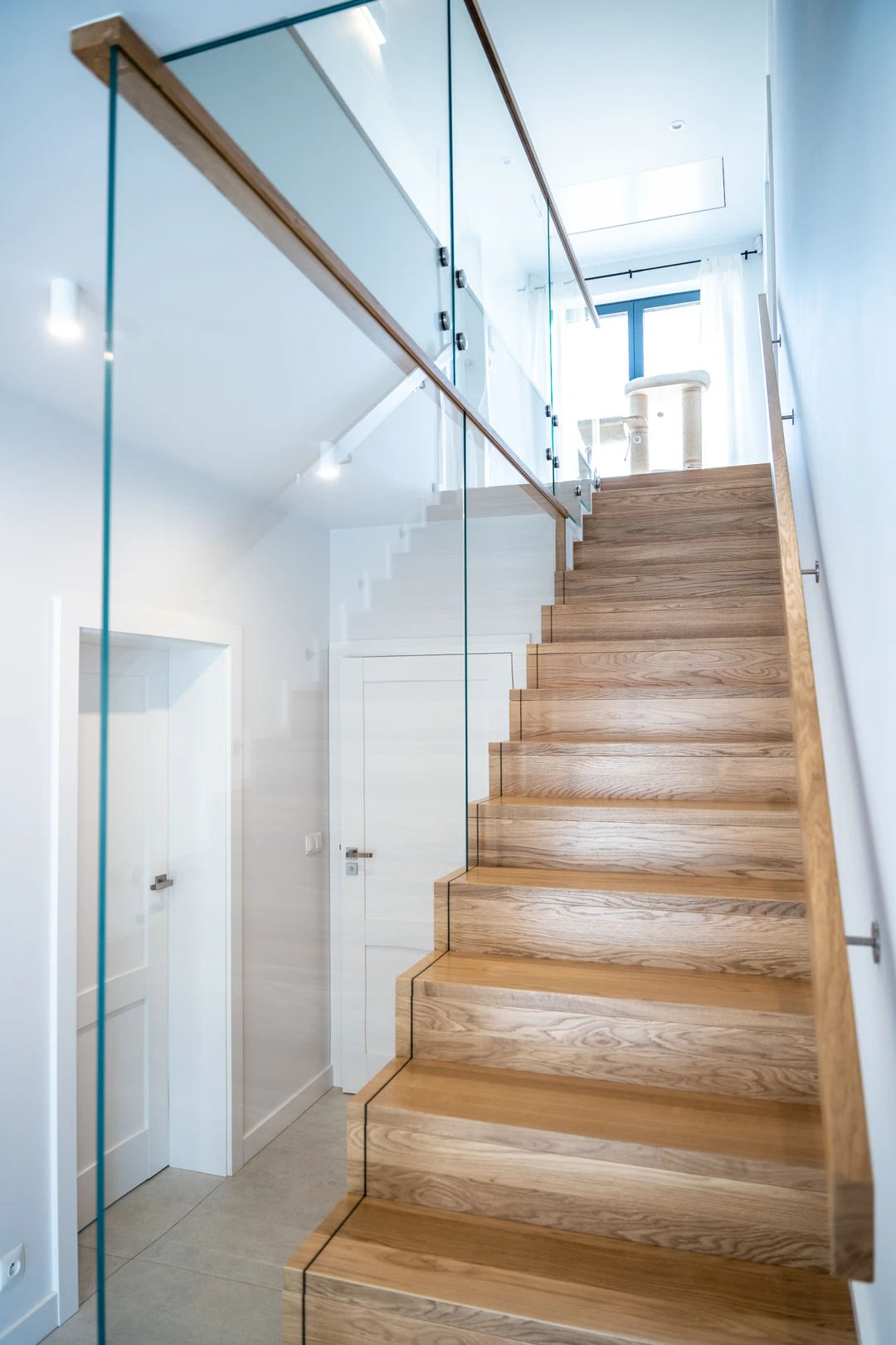 Moderne Stufen auf Beton (Treppe in Faltwerkoptik) mit eingelassenem Glasgeländer, Holzhandlauf und Holzstufen  9