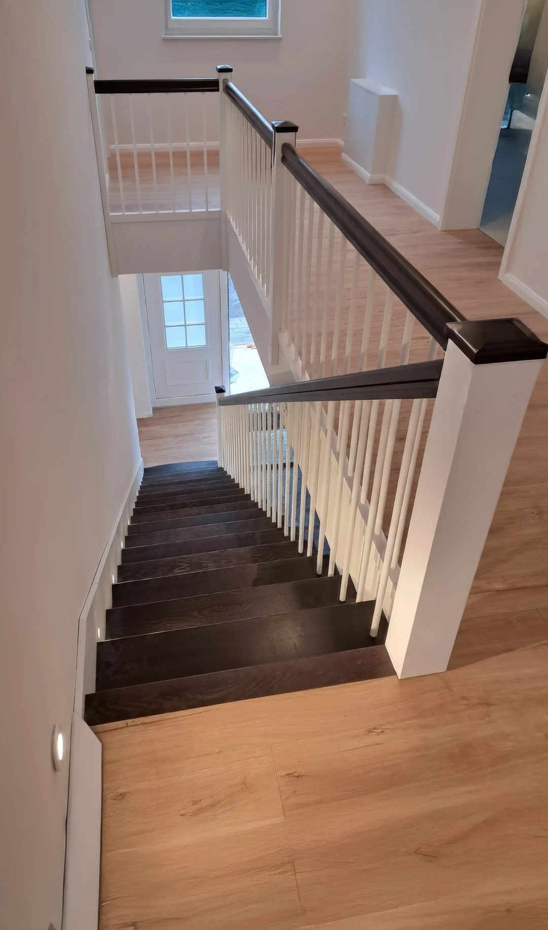 Treppe mit weißer Wange innen, dunkel gebeizten Stufen und LED-Beleuchtung 1