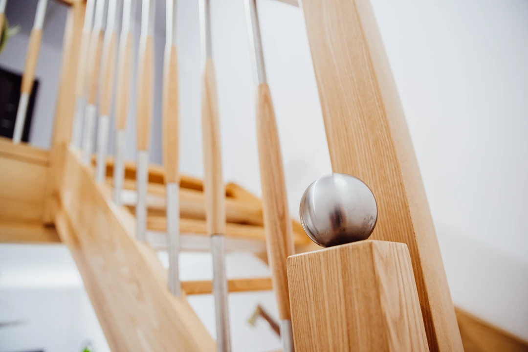 Wangentreppe mit Geländerstäben und Handlauf aus Esche, in Naturholzfarbe lackiert  1