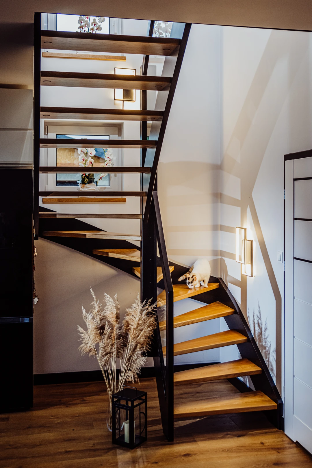 Wangentreppe mit Glasgeländer, lackierten Stufen in Naturholzfarbe sowie schwarzen Wangen, Pfosten und Handlauf  2