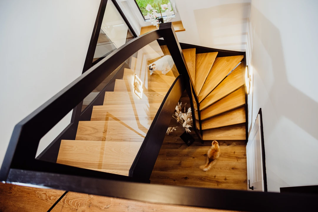 Wangentreppe mit Glasgeländer, lackierten Stufen in Naturholzfarbe sowie schwarzen Wangen, Pfosten und Handlauf  5