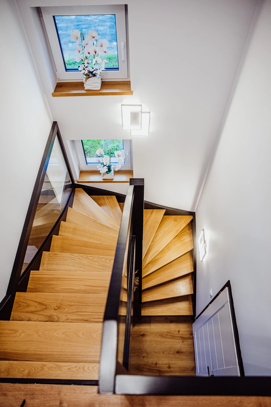 Wangentreppe mit Glasgeländer, lackierten Stufen in Naturholzfarbe sowie schwarzen Wangen, Pfosten und Handlauf  6