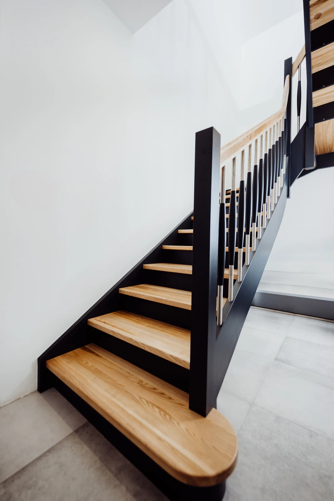 Wangentreppe mit Holzstufen in Naturholzfarbe, Wangen und Setzstufen in Schwarz  1