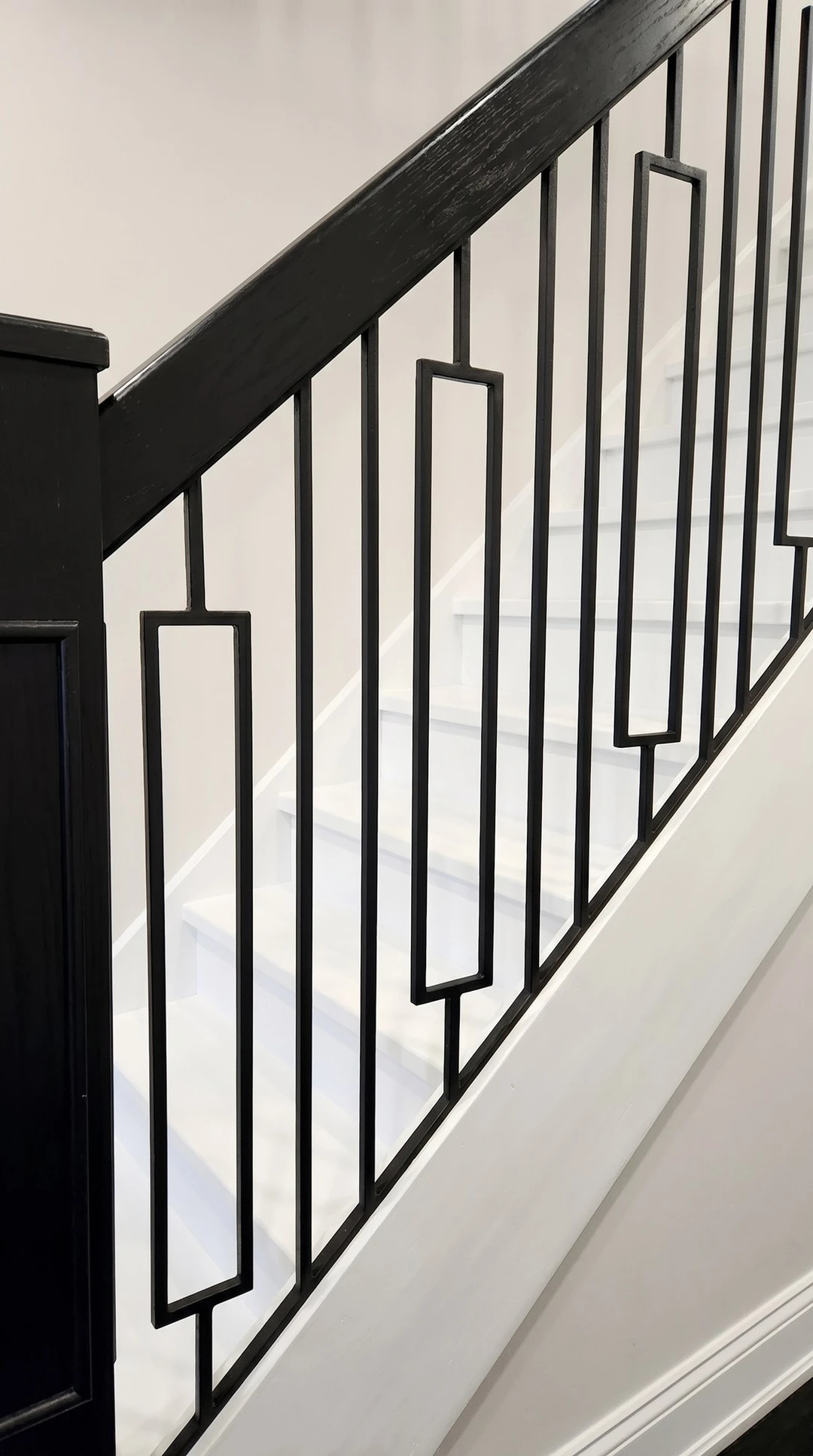 Weiß lackierte Treppe mit schwarzem Metallgeländer und Blockstufe 1
