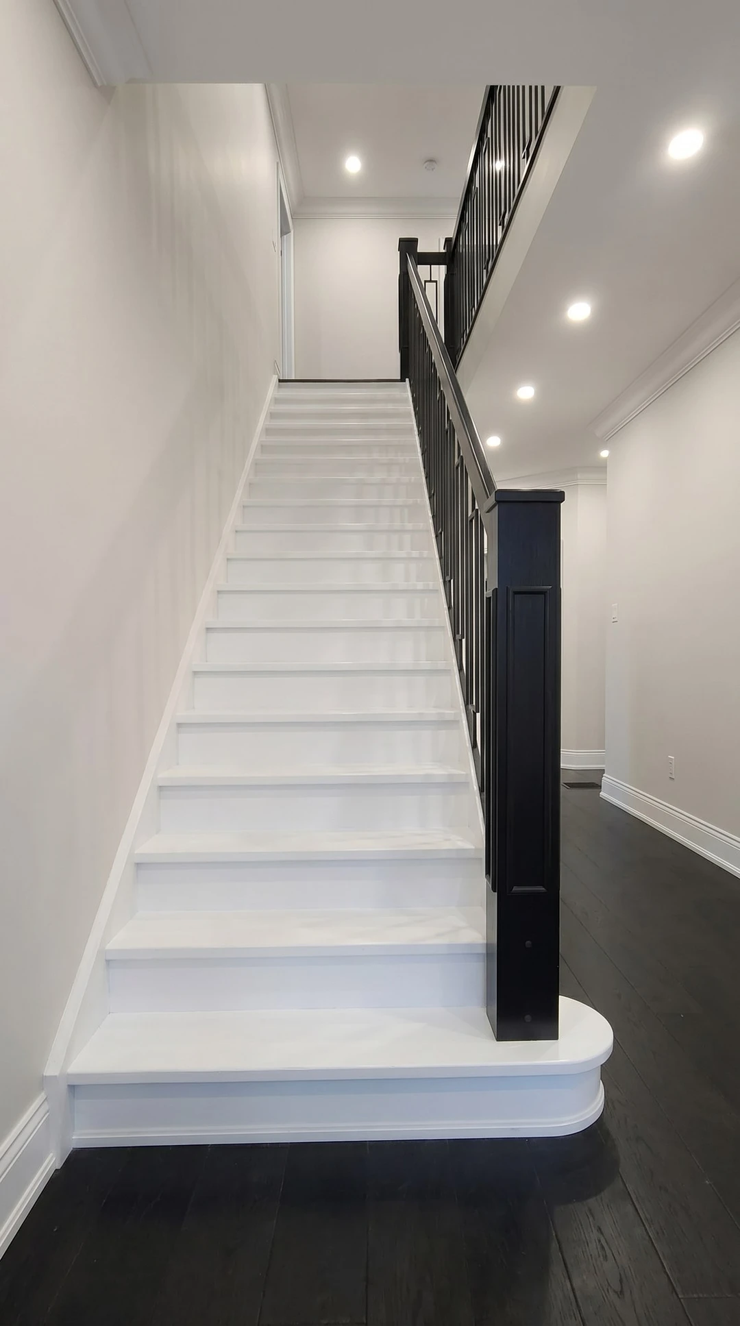 Weiß lackierte Treppe mit schwarzem Metallgeländer und Blockstufe 2