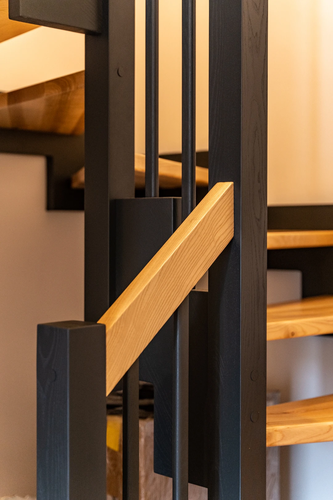 Zahnwangentreppe mit Geländerstäben, schwarzer Konstruktion sowie lackierten Stufen und Handlauf aus Esche in Naturholzfarbe  5
