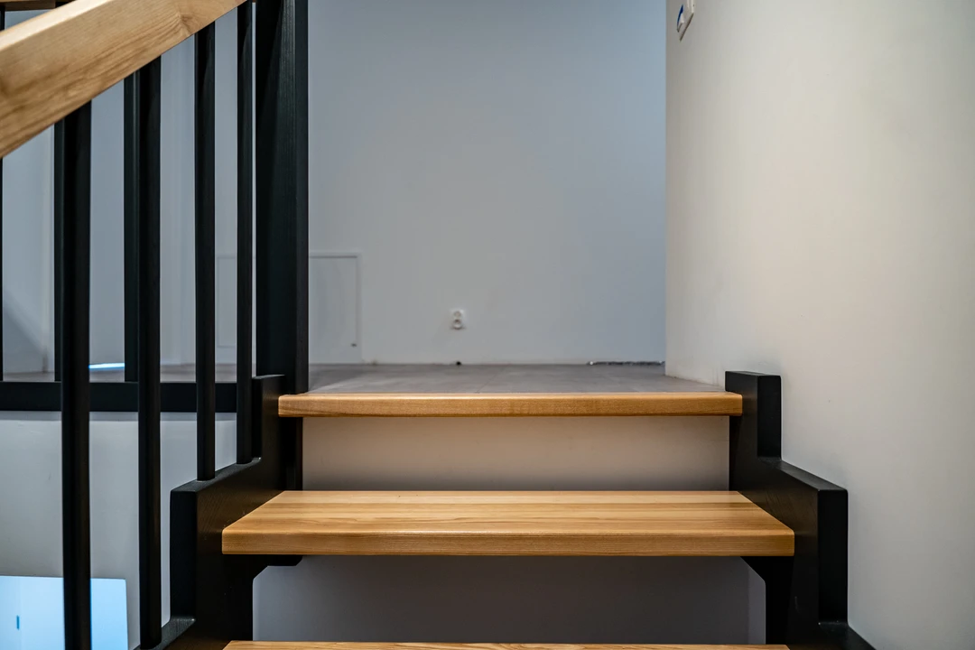 Zahnwangentreppe mit Geländerstäben, schwarzer Konstruktion sowie lackierten Stufen und Handlauf aus Esche in Naturholzfarbe  7