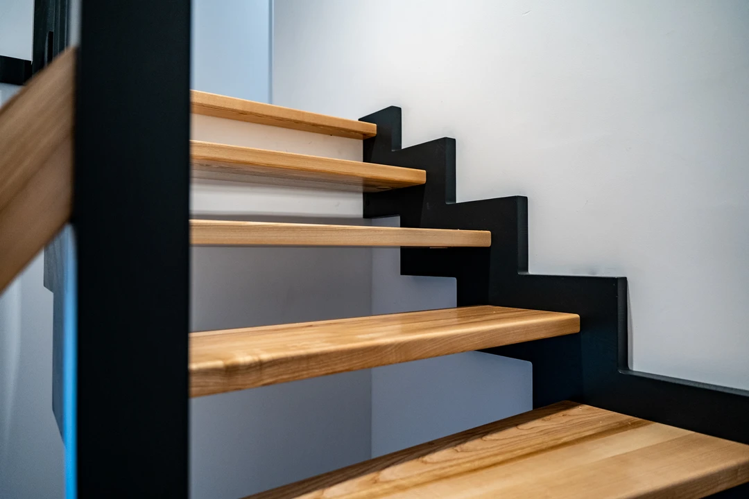 Zahnwangentreppe mit Geländerstäben, schwarzer Konstruktion sowie lackierten Stufen und Handlauf aus Esche in Naturholzfarbe  8