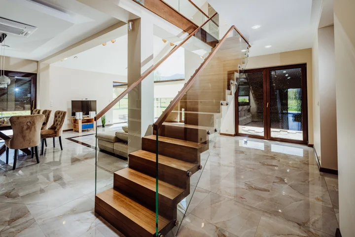 Holztreppe innen: moderne Faltwerktreppe mit Glasgeländer und Holzhandlauf