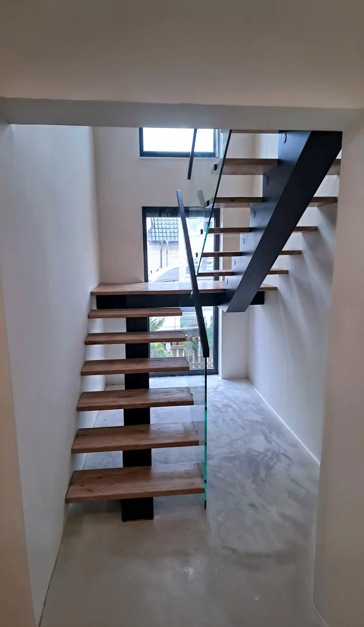 Moderne Mittelholmtreppe mit lackierten Holzstufen